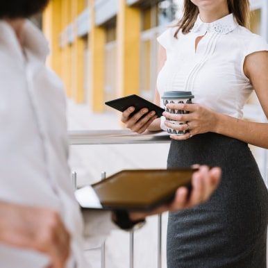 Zwei Geschäftsfrauen besprechen Unterlagen auf einem Tablet