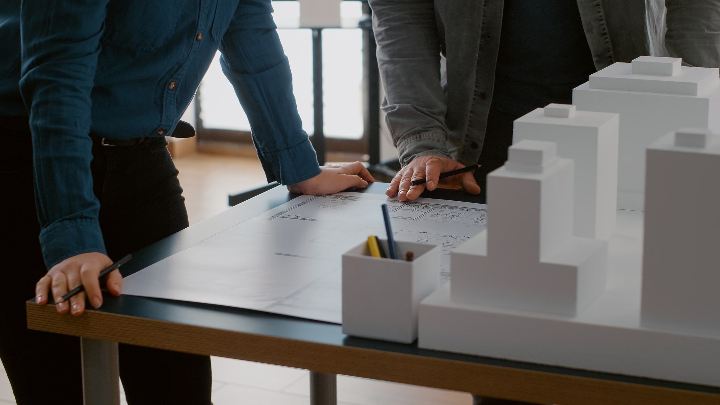 Team bespricht Baupläne an einem Tisch mit weißem Architekturmodell